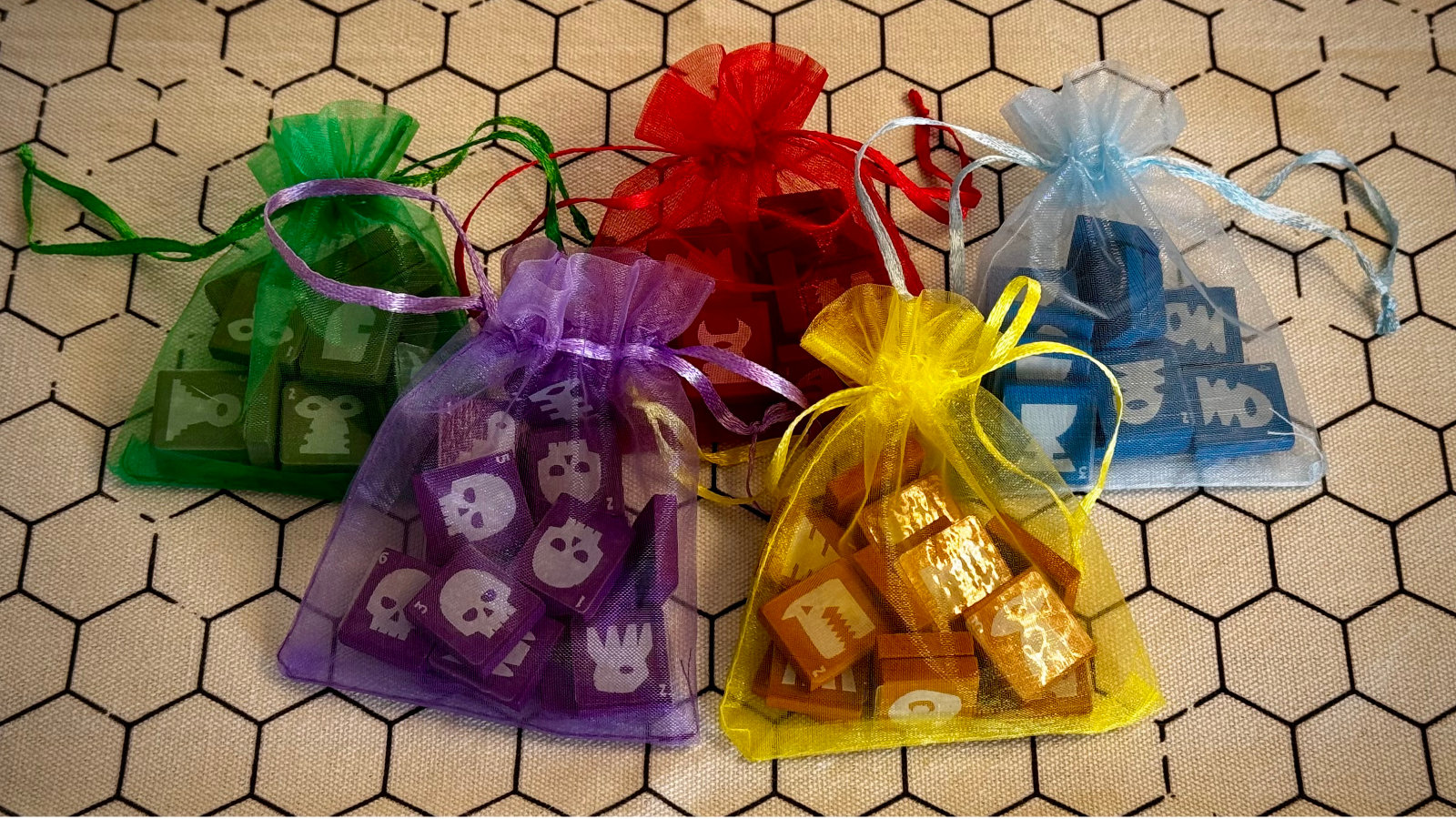 QuoDrox tiles spilling out of a dice bag alongside dice, showing how compact and portable the set is